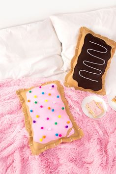 an instagram photo with a pink bed and pillows on it, including a cake in the shape of a letter