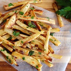 french fries with herbs and parsley on a cutting board