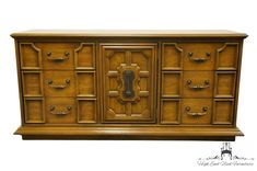 an old wooden cabinet with many drawers and pulls on the doors, which are painted gold