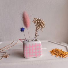 a vase with some flowers in it sitting on a table next to other items and accessories