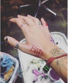 a person's hand with tattoos on it next to a sink and other items