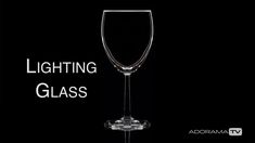 a wine glass sitting on top of a black background with the words lighting glass above it