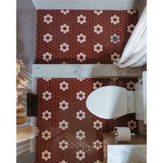 a bathroom with red and white tiles on the walls