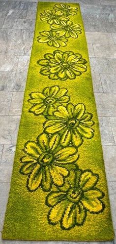 a long green rug with flowers on it