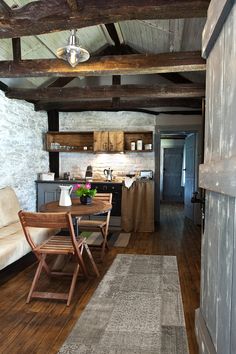 a living room and kitchen area with wood flooring in an old style house or home