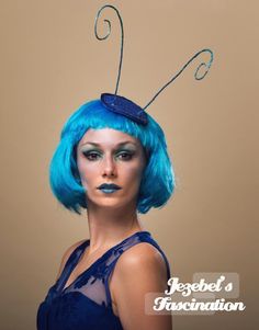 a woman with blue hair and an insect on her head