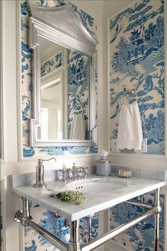 a white sink sitting under a bathroom mirror next to a wall mounted faucet