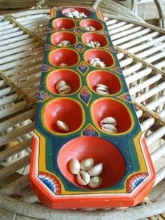 there are many cups on the table with nuts in them and one is red, green, yellow and blue