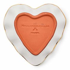 an orange and white heart shaped dish