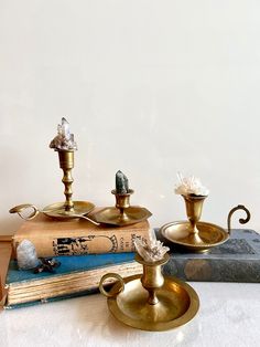 antique brass candlestick holders and books on a table