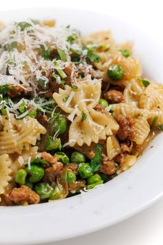 a white plate topped with pasta and peas