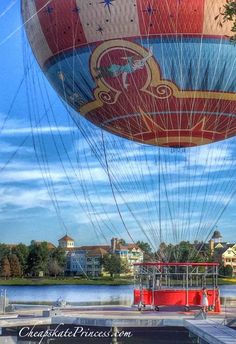 a large hot air balloon flying over a lake