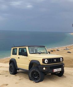 a yellow jeep is parked on the beach