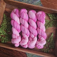 several skeins of pink yarn in a wooden box