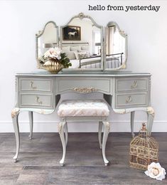 an antique vanity with mirror and stool in front of it