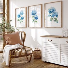 a white room with three blue flowers on the wall and a wicker chair next to it