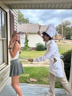 a man and woman dressed in costumes standing on a porch next to each other,