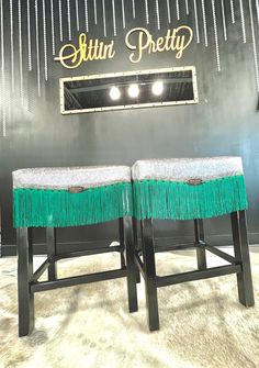 two stools with fringe on them in front of a sign that reads altun pretty