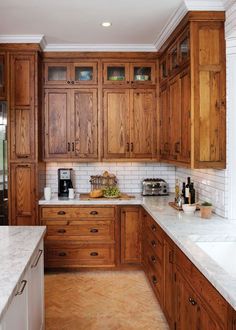 a kitchen with wooden cabinets and marble counter tops