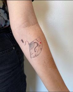 a woman's arm with a tattoo on it that has a kite flying in the sky