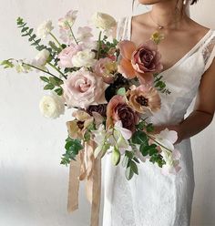 a woman holding a bouquet of flowers in her hands