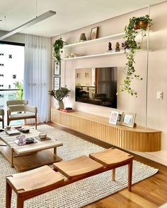 a living room filled with furniture and a flat screen tv mounted on a wall next to a window