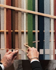 a man is working on an upholstered wall with different colored carpet swatches