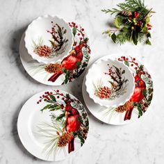 three white plates with red birds on them