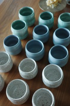 several blue and white vases sitting on top of a wooden table next to each other