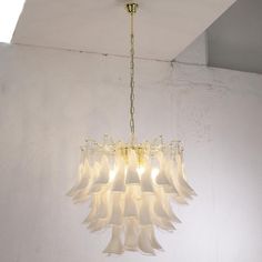 a chandelier hanging from the ceiling in a room with white walls and flooring