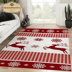 a red and white rug with reindeers on it in front of a couch next to a potted plant