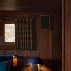 a living room with wood paneling and blue furniture