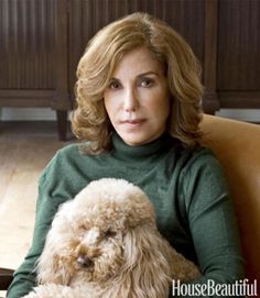 a woman sitting in a chair holding a dog