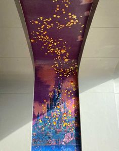 a painting on the side of a building that is painted with gold and purple colors