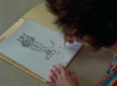 a person is drawing on a piece of paper