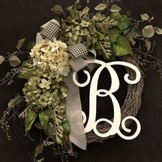 a monogrammed wreath with the letter b is displayed on a black tablecloth