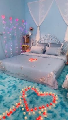 a bedroom decorated in blue and white with lights on the bed