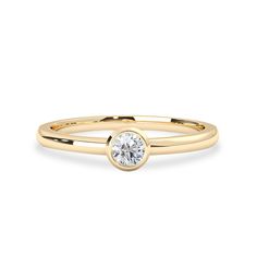 a yellow gold ring with a single diamond in the center, on a white background