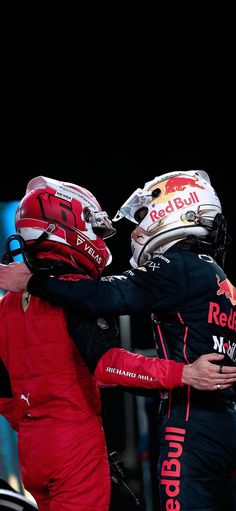 two men in racing gear hugging each other