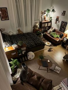 an overhead view of a living room with couches, coffee table and bookshelf