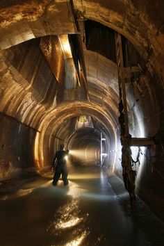 a man standing in the middle of a tunnel