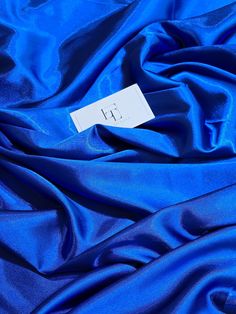 a blue fabric with a white tag on it's end that reads 1 / 2