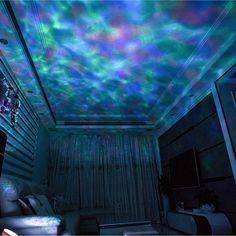 a living room filled with lots of furniture under a colorful sky light fixture on the ceiling