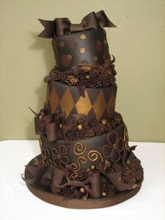 a three tiered chocolate cake sitting on top of a table