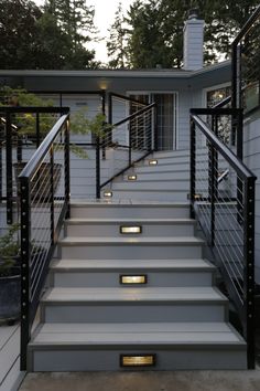 some stairs leading up to a house with lights on the bottom and side steps in front