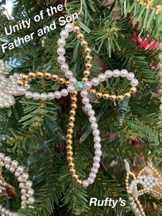 a christmas tree decorated with pearls, beads and a starfish ornament that reads, unit of the father and son