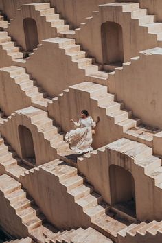 a woman in white dress walking on steps made out of cement blocks and concrete blocks