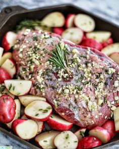 a piece of meat and apples in a pan with seasoning on the top, ready to be eaten