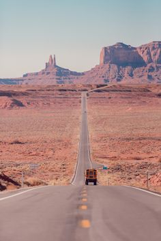 a truck driving down the middle of a desert road