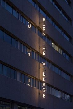 a tall building with the words burn on it's side lit up at night